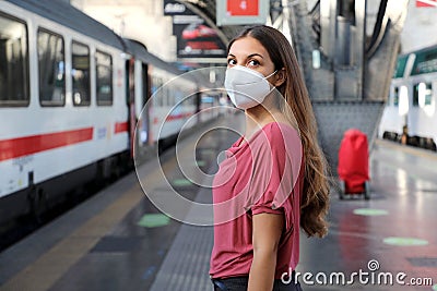 Portrait of casual woman waiting train with KN95 FFP2 protective mask at train station Stock Photo