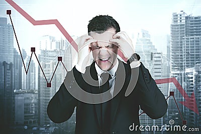 Stressful businessman with declining finance chart Stock Photo