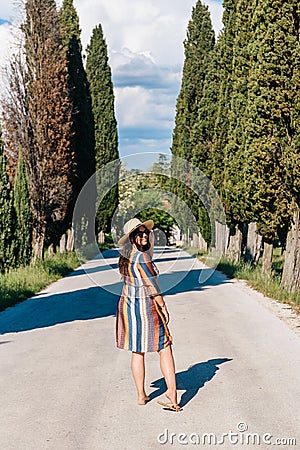 Portrait of a Caucasian female wearing a sun dress in the middle of a dirt road Stock Photo