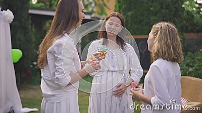Portrait of Caucasian happy pregnant woman smiling talking with girls standing on backyard. Satisfied mother and stock footage Portrait of Caucasian happy pregnant woman smiling talking with girls standing on backyard. Satisfied mother and stock footage