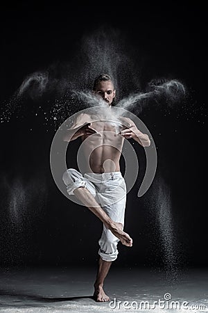 Portrait of caucasian young man wearing white sport pants doing yoga or pilates exercise. Stock Photo