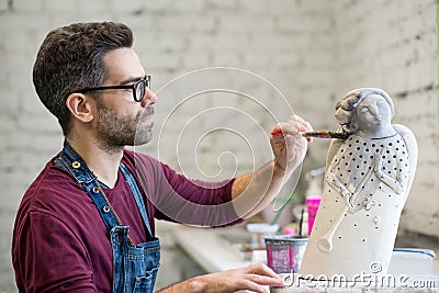 Portrait of Ceramist Dressed in an Apron Working on Clay Sculpture in Bright Ceramic Workshop. Stock Photo