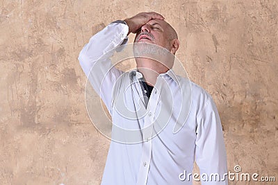 portrait of charming man in black and white shirt with gray beard and bald head feeling pain Stock Photo