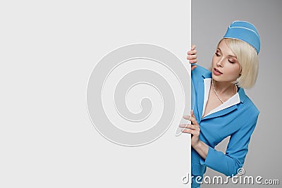 Portrait of charming stewardess wearing in blue uniform. Empty billboard Stock Photo