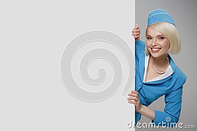 Portrait of charming stewardess wearing in blue uniform. Empty billboard Stock Photo