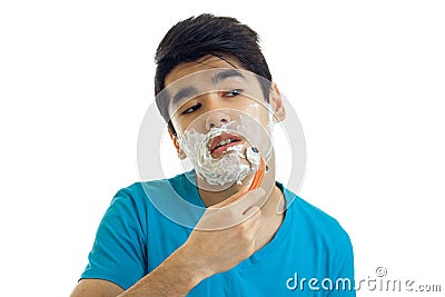 Portrait of a charming young man who tilted his head and gently shaves his beard machine Stock Photo