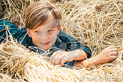 Portrait of a cheerful boy lying in a hay. Autumn dream. Kid dreams on autumn nature. Childhood dream concept Stock Photo