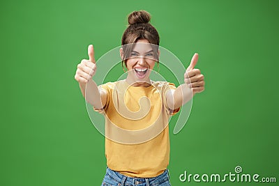 Portrait of cheerful enthusiastic and excited emotive beautiful european woman in yellow t-shirt pulling hands with Stock Photo