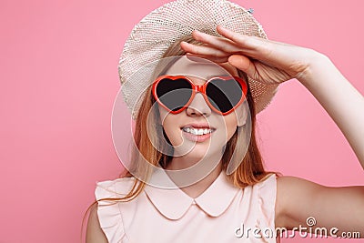 Portrait of a cheerful girl in a summer hat and heart-shaped sunglasses waiting for a vacation Stock Photo