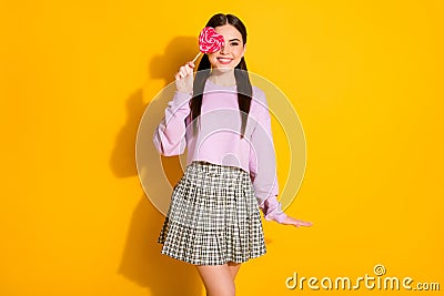 Portrait of cheerful lovely cute sweet girl teen close cover her eye with heart shape candy wear jumper isolated over Stock Photo