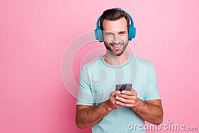 Portrait of cheerful modern hipster man have free time listen music blue headset use smartphone search amusing stereo Stock Photo