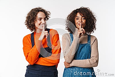 Portrait of cheerful multinational women gesturing silence sign Stock Photo