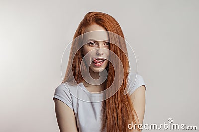 Portrait of a cheerful redhaired emotional woman in positive mood at studio. Stock Photo