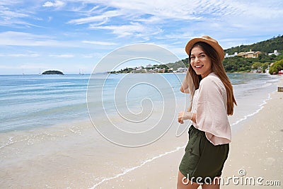 Portrait of cheerful stylish traveler woman on Jurere beach, Florianopolis, Santa Catarina Island, Brazil. Copy space Stock Photo