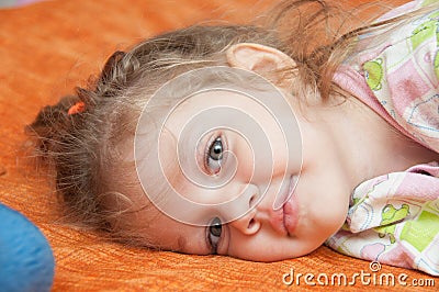 Portrait of cheerful three-year girl lying on the couch Stock Photo