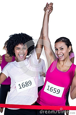 Portrait of cheerful winner athletes crossing finish line with arms raised Stock Photo