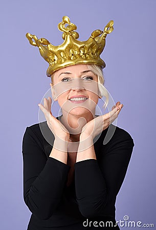 Portrait of cheerful woman with golden crown Stock Photo