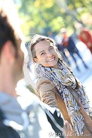Portrait of cheerful woman pulling her boyfriend Stock Photo