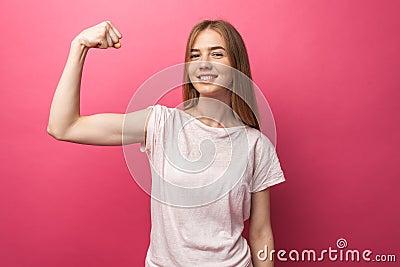 Portrait of cheerful young girl bending biceps on pink background, cute and attractive, Stock Photo