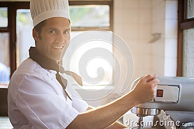 Portrait of chef blending the batter in mixing blender Stock Photo