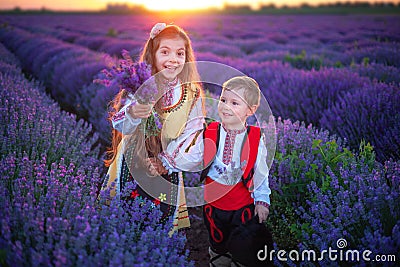 Portrait of children boy and girl in traditional Bulgarian folklore costume in lavender field during sunset Stock Photo