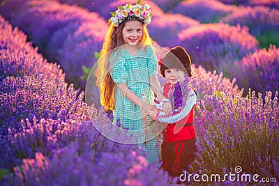 Children boy and girl in traditional Bulgarian folklore costume in lavender field during sunset Stock Photo