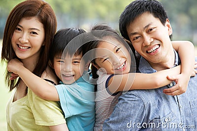 Portrait Of Chinese Family Relaxing In Park Stock Photo