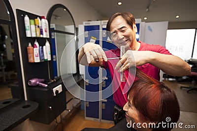 Portrait of chinese hairdresser cutting customer hair in salon Stock Photo