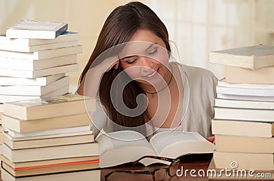 Portrait of clever student with open book reading in college library Stock Photo