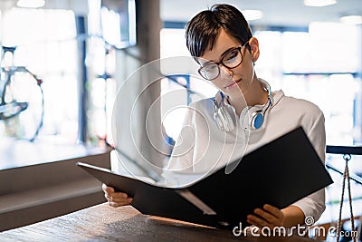 Portrait of clever student reading book in college library Stock Photo