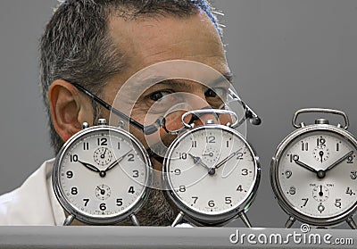 Clockmaker portrait behind his alarm clocks Stock Photo