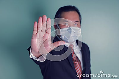 Portrait close up at to hand businessman showing the stop sign. Asian businessman portrait wears a black suit wearing medical Stock Photo