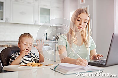 Working mother with child in the kitchen Stock Photo