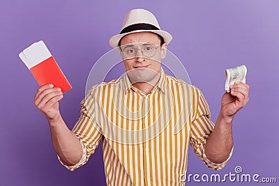 Portrait of clueless unsure guy hold tickets dollar banknote shrug shoulders on purple background Stock Photo