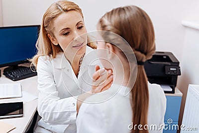 Portrait of competent doctor while examining throat Stock Photo