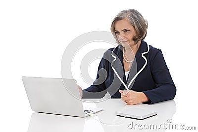 Portrait: competent senior businesswoman sitting at desk with co Stock Photo