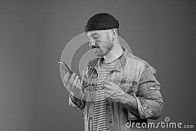 Portrait of concentrated stylish man reading text messages on his cell phone Stock Photo