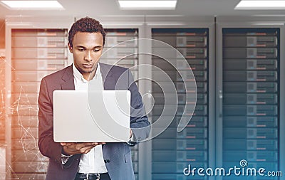 African American man with laptop in a server room Stock Photo