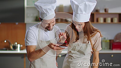 Portrait of confectioners decorating dessert with cherry on kitchen Stock Photo