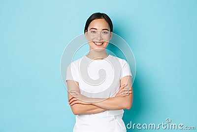 Portrait of confident asian girl smiling pleased, cross arms chest confident pose, female student looking upbeat and Stock Photo