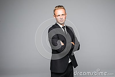 Portrait of a confident businessman with arms folded over gray background. Looking at camera Stock Photo