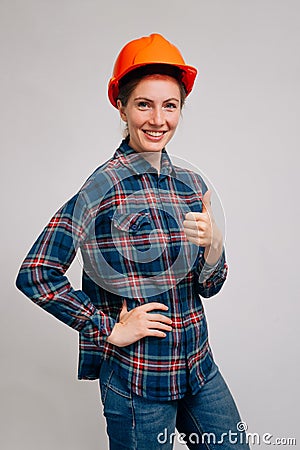Portrait of a confident cheerful builder woman on a light background,Successful deal concept Stock Photo