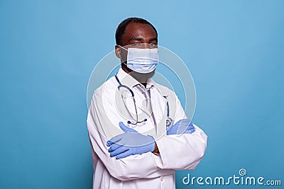 Portrait of confident doctor wearing scrubs with face mask and latex gloves Stock Photo