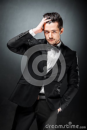 Portrait of confident handsome man in black suit with bowtie Stock Photo