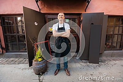 Portrait of confident male salesperson standing arms crossed outside coffee store Stock Photo