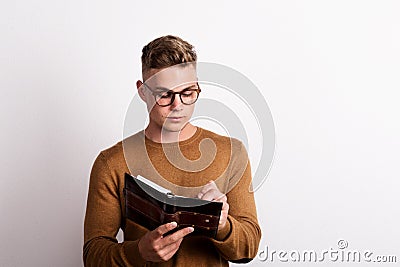 Portrait of a confident young man in a studio, making notes in a personal diary. Copy space. Stock Photo