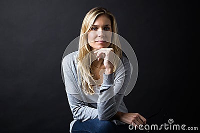 Confident young woman looking at camera over black background Stock Photo