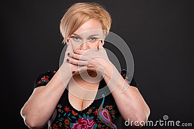 Portrait of cool fashionable woman posing covering mouth Stock Photo