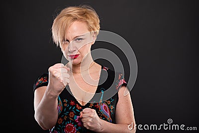 Portrait of cool fashionable woman posing showing fists Stock Photo