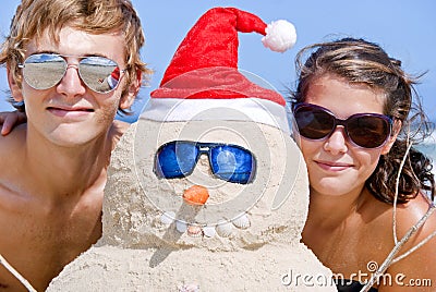 Portrait of couple and sand snowman on beach Stock Photo